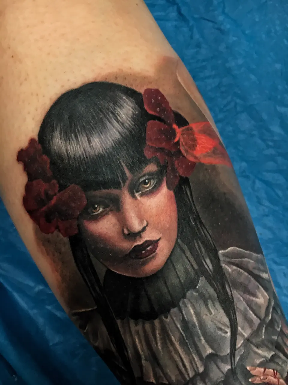 Portrait-Tattoo einer Frau mit roten Rosen im Haar